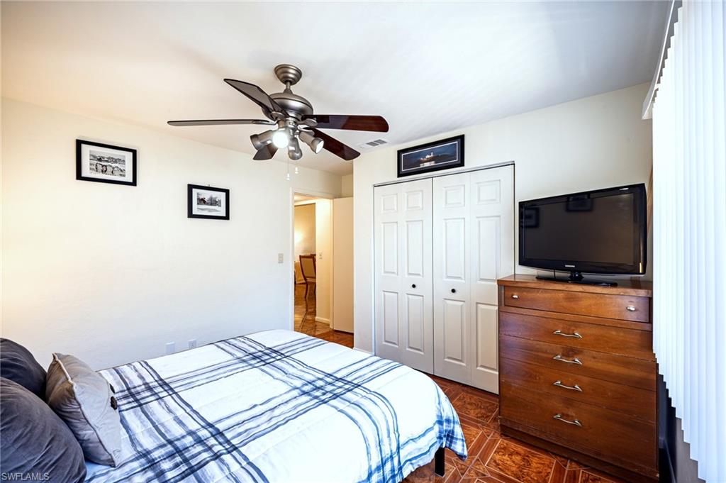 3420 Frosty Way, Unit 4902 Naples, FL 34112 - Photo 12 of 31 a bedroom with a bed and a flat screen tv