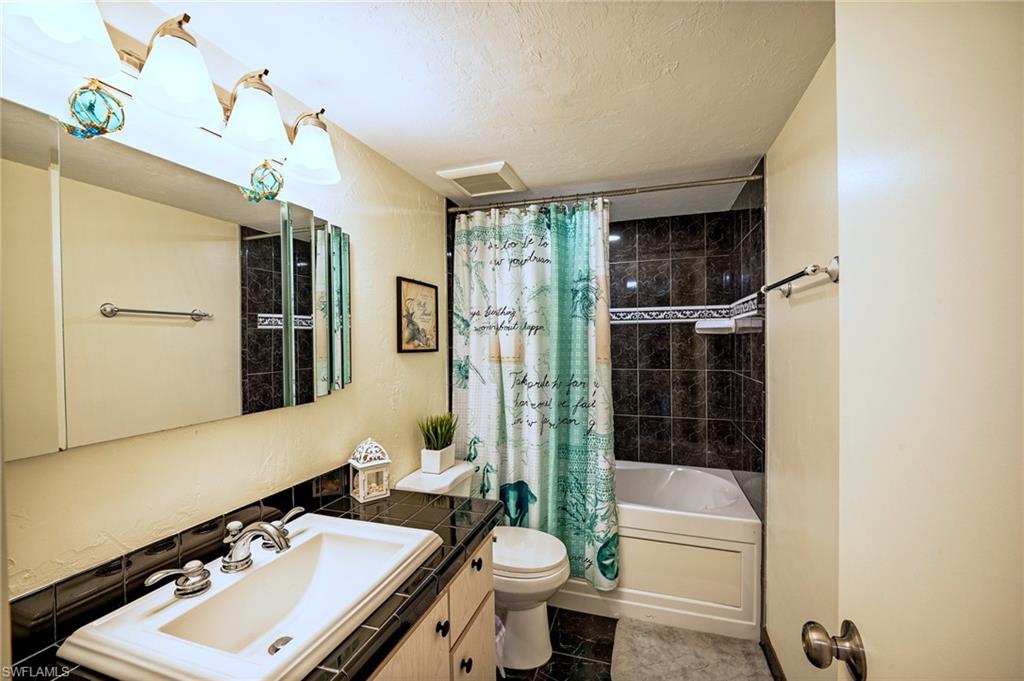 3420 Frosty Way, Unit 4902 Naples, FL 34112 - Photo 13 of 31 a bathroom with a sink a toilet a mirror and shower