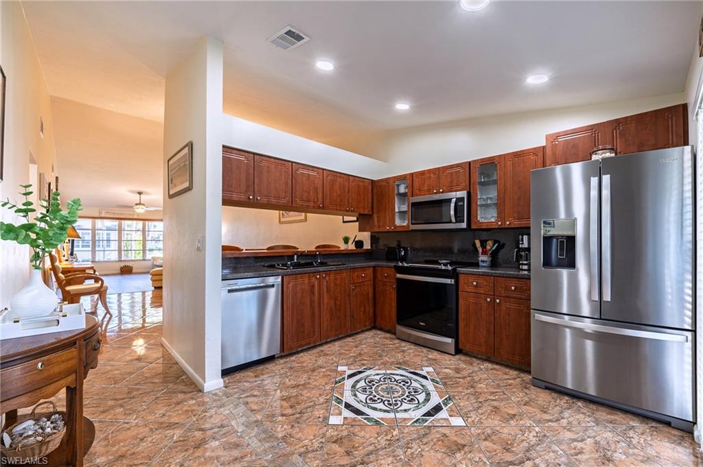 3420 Frosty Way, Unit 4902 Naples, FL 34112 - Photo 2 of 31 a kitchen with stainless steel appliances granite countertop a refrigerator sink and stove