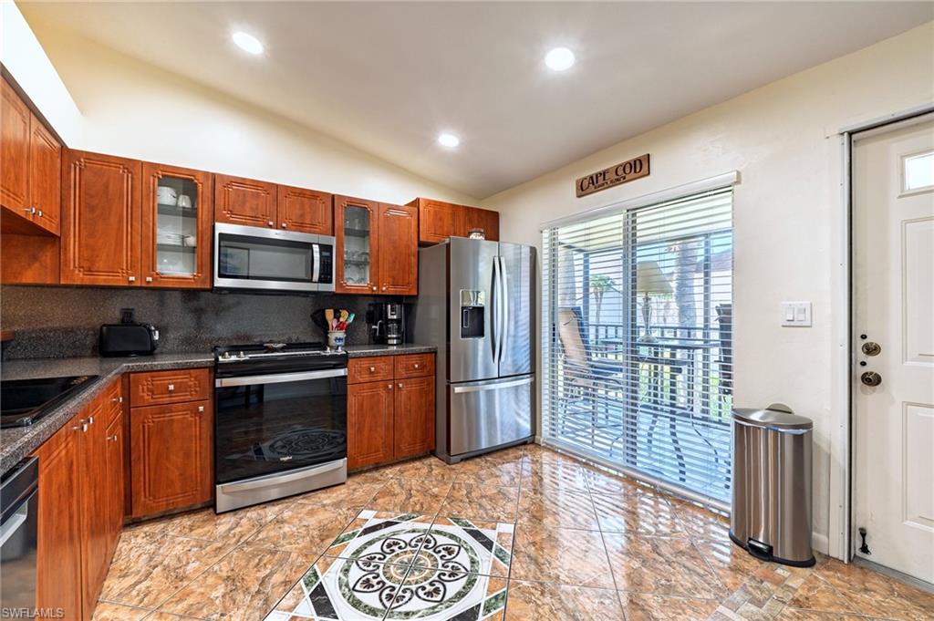 3420 Frosty Way, Unit 4902 Naples, FL 34112 - Photo 4 of 31 a kitchen with stainless steel appliances granite countertop a refrigerator stove and cabinets