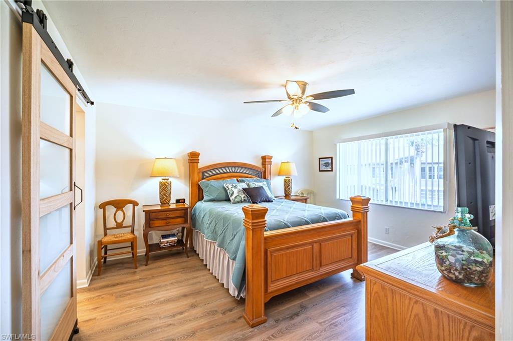 3420 Frosty Way, Unit 4902 Naples, FL 34112 - Photo 7 of 31 a bedroom with bed and wooden floor