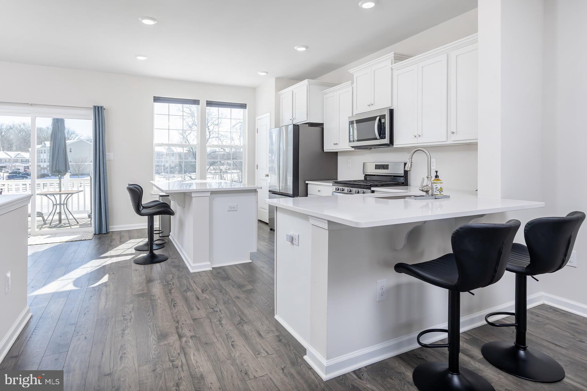 18 Foundry Boulevard Mount Holly, NJ 08060 - Photo 2 of 20 a kitchen with stainless steel appliances granite countertop a stove a sink a refrigerator and white cabinets with wooden floor
