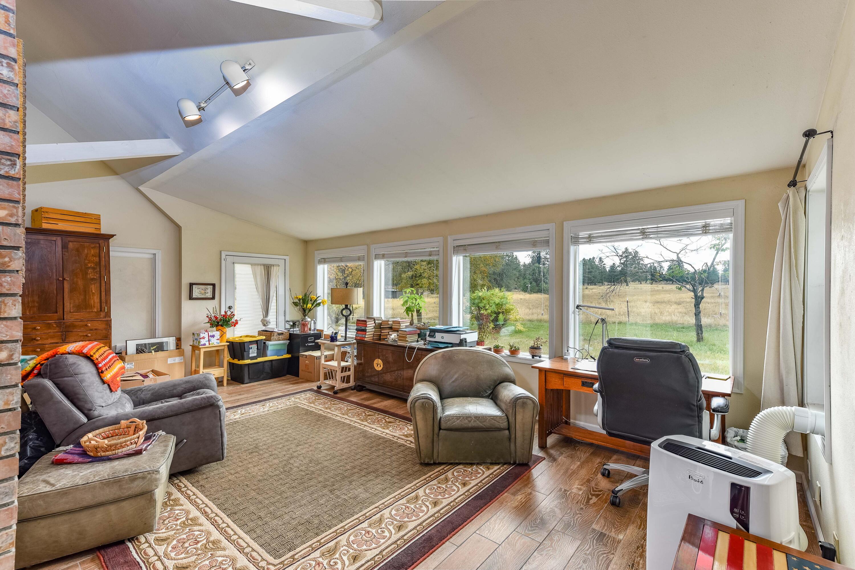 21698 Rickard Road Bend, OR 97702 - Photo 17 of 51 Sunroom currently being used as an office but could be a nice area for a big dining room table and sitting area to enjoy the big windows looking out to the expansive property.