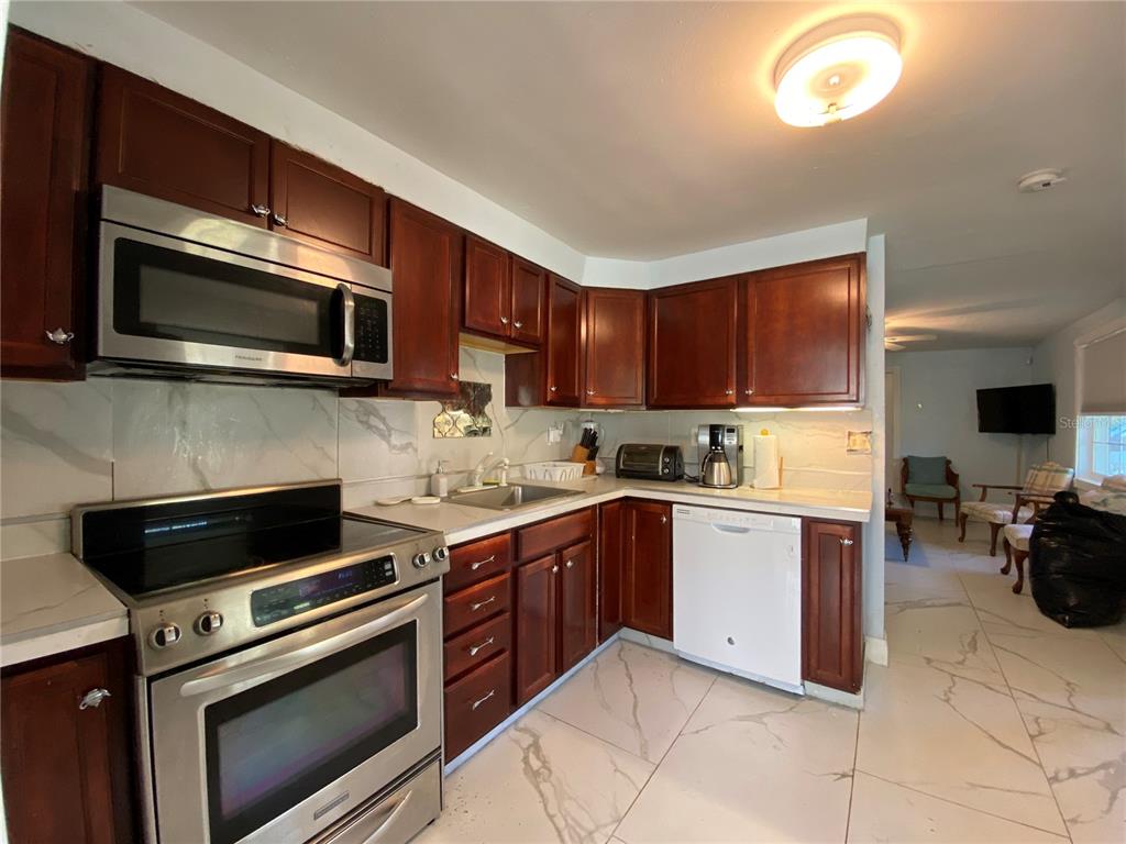 910 Lake Avenue Edgewater, FL 32132 - Photo 10 of 23 a kitchen with stainless steel appliances granite countertop a stove microwave and sink
