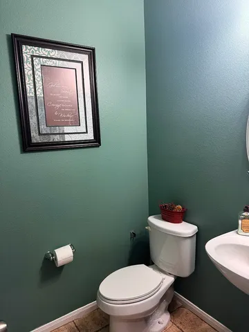 a white toilet sitting next to a bathroom sink