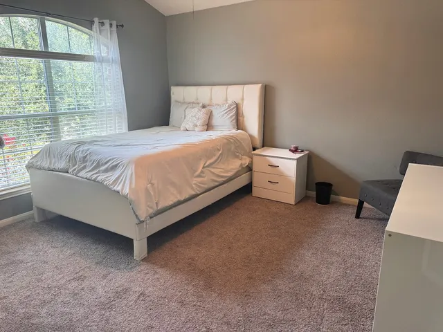 a spacious bedroom with a bed and a large window