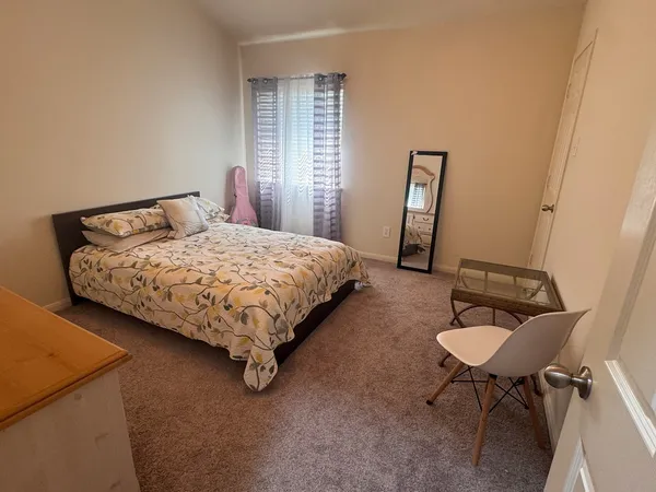 a bed sitting in a bedroom next to a window