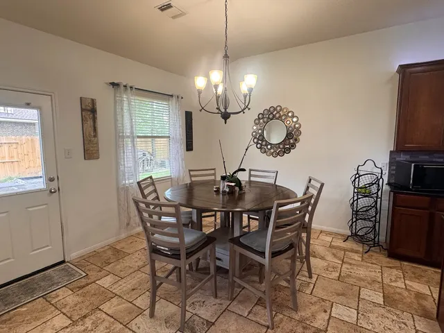 a view of a dining room with furniture and chandelier