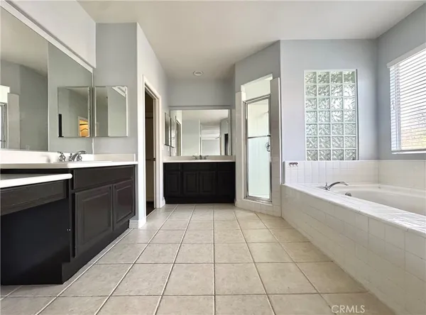 a view of an empty room with wooden floor and a mirror
