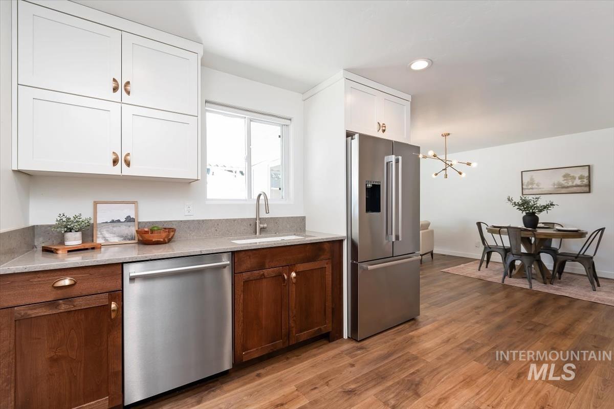 2217 North Middlefield Road Boise, ID 83704 - Photo 15 of 34 Modern kitchen featuring white upper cabinetry, rich wood-finish lower cabinetry, and stainless steel appliances