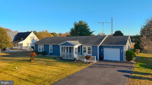 a view of a white house with a swimming pool and a yard