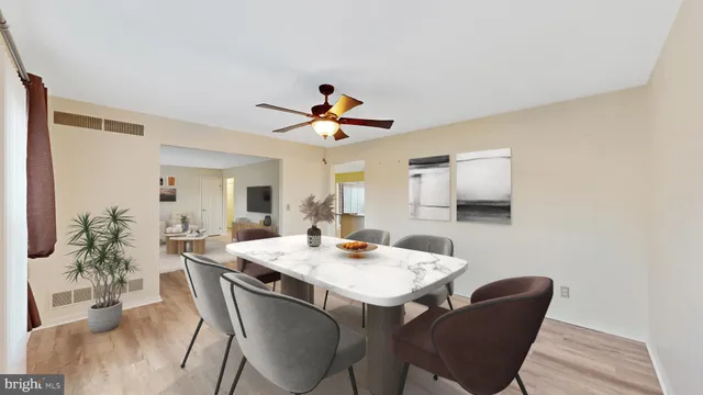 an empty room with a kitchen and a ceiling fan