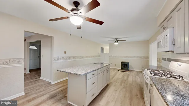 a kitchen with a refrigerator and white cabinets