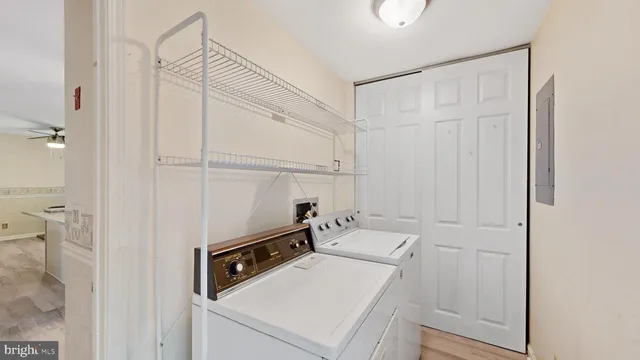 a kitchen with a sink dishwasher a stove and white cabinets with wooden floor