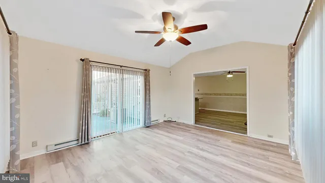 a view of a livingroom with wooden floor and a large window with pool view