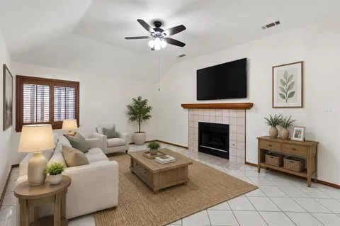 a living room with furniture a fireplace and a flat screen tv