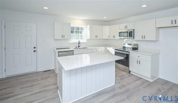 a kitchen with stainless steel appliances granite countertop a sink stove and wooden floor