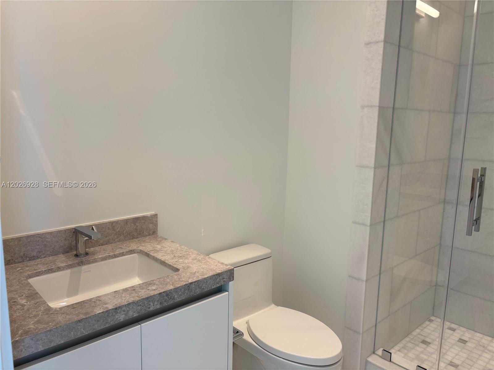 175 Southeast 25th Road, Unit 901 Miami, FL 33129 - Photo 12 of 18 a bathroom with a granite countertop sink toilet and shower