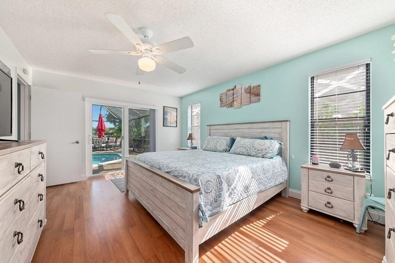 9535 Ohio Place Boca Raton, FL 33434 - Photo 6 of 16 a spacious bedroom with a large bed and a chandelier
