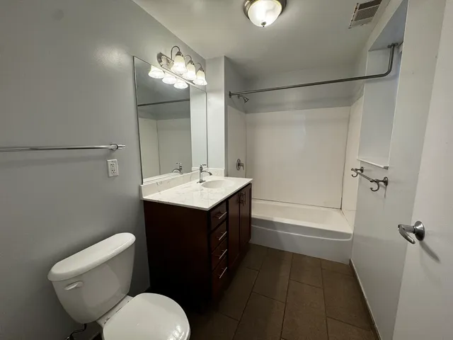 a bathroom with a sink a toilet a mirror and shower