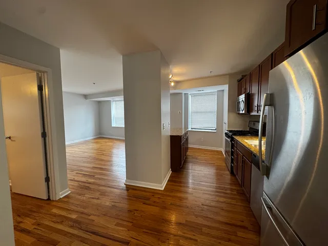 a view of a hallway with wooden floor and staircase