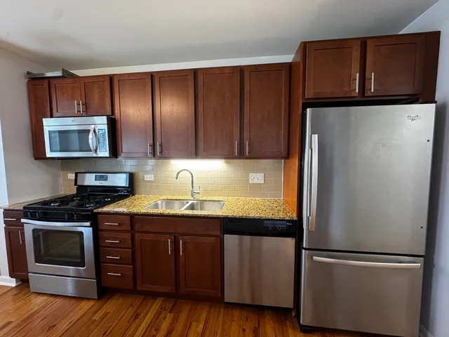 a kitchen with granite countertop stainless steel appliances and wooden cabinets