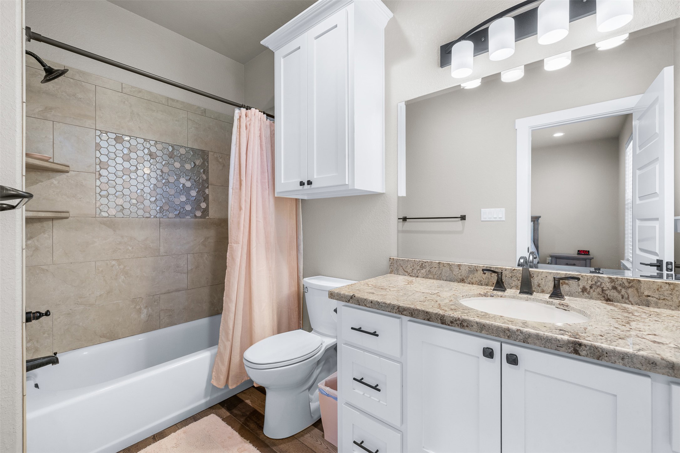 1306 22 Hills Road Gause, TX 77857 - Photo 26 of 40 Bathroom featuring a white vanity with an undermount sink, a patterned stone countertop, and dark bronze fixtures