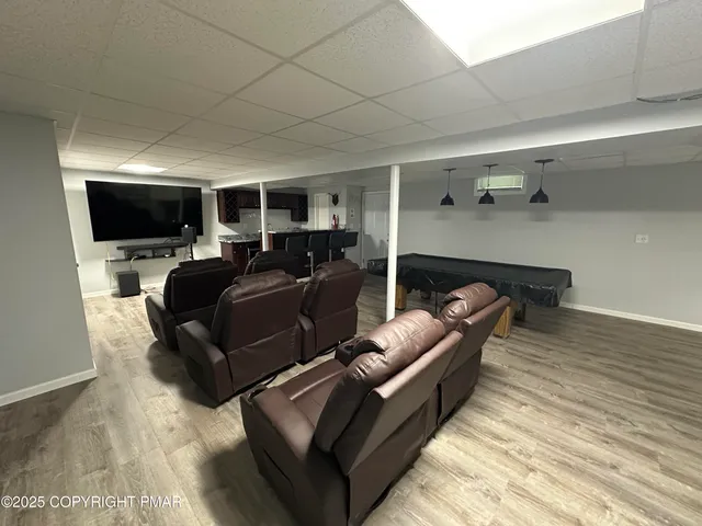 a living room with furniture a flat screen tv and a wooden floor