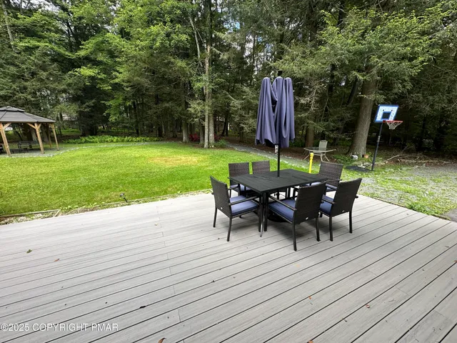 a view of a table and chairs in backyard of the house