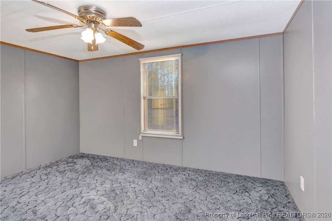 6461 Wire Grass Road Orrum, NC 28369 - Photo 17 of 22 a view of a bedroom with a chandelier fan and wooden floor