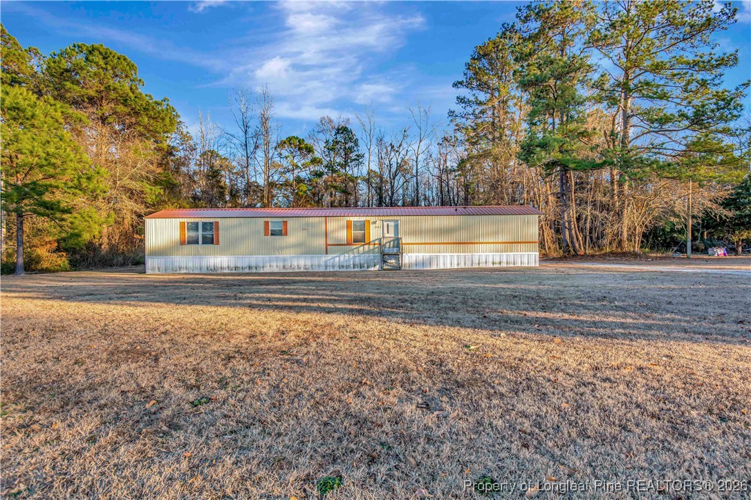6461 Wire Grass Road Orrum, NC 28369 - Photo 2 of 22 a view of backyard with large trees and plants
