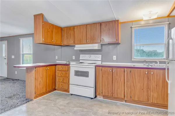 a kitchen with a sink a stove and cabinets