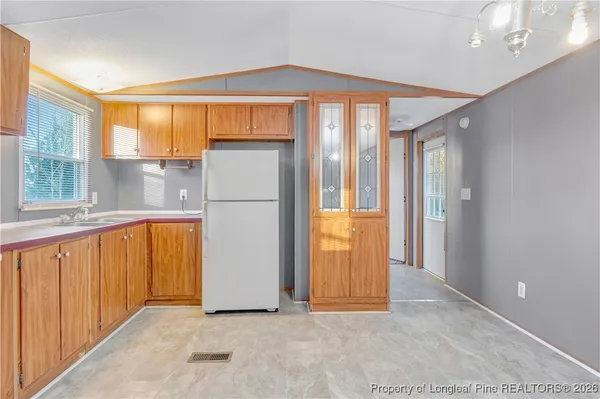 a view of a kitchen with a refrigerator and a sink