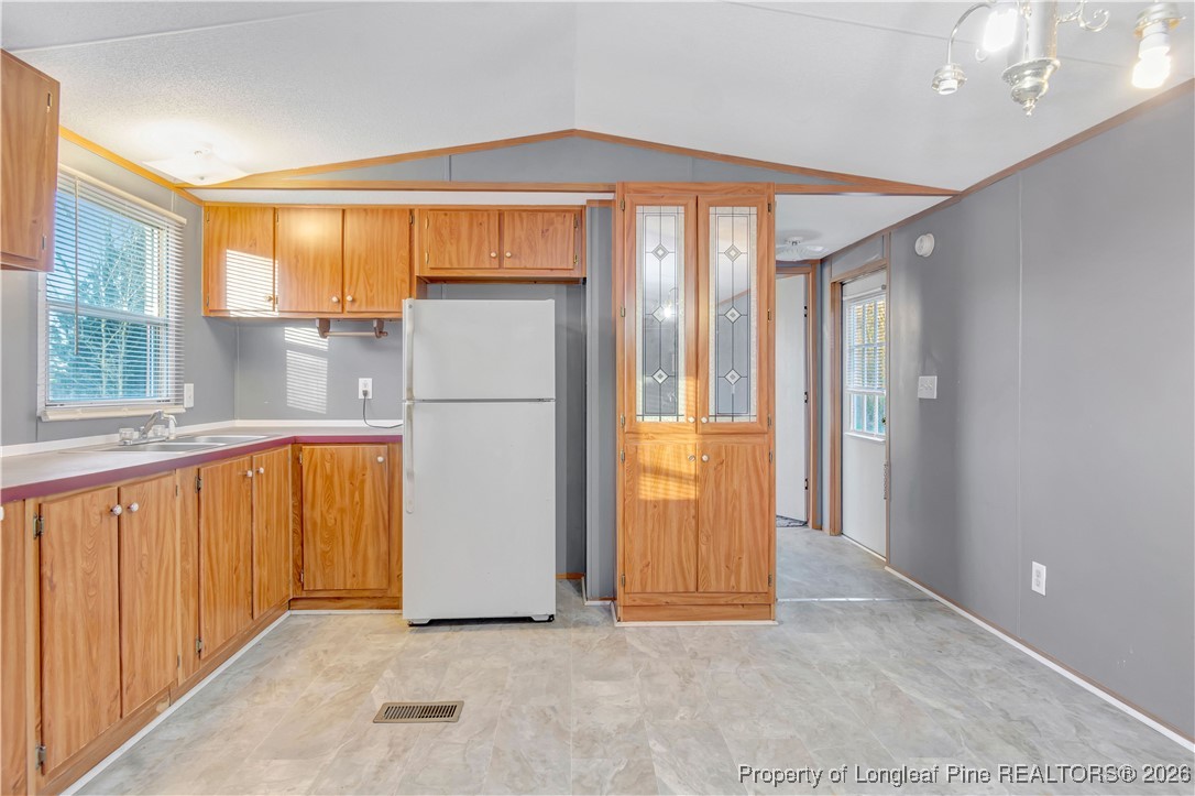 6461 Wire Grass Road Orrum, NC 28369 - Photo 8 of 22 a view of a kitchen with a refrigerator and a sink