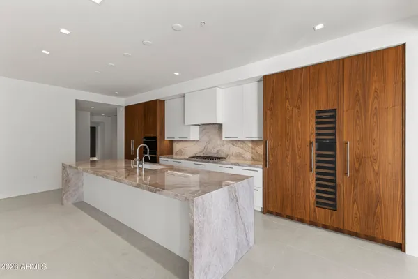 a large kitchen with a large counter top stainless steel appliances and cabinets