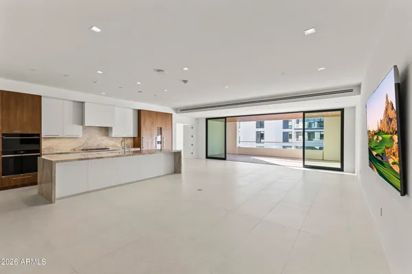 a large white kitchen with kitchen island a sink a refrigerator and a stove