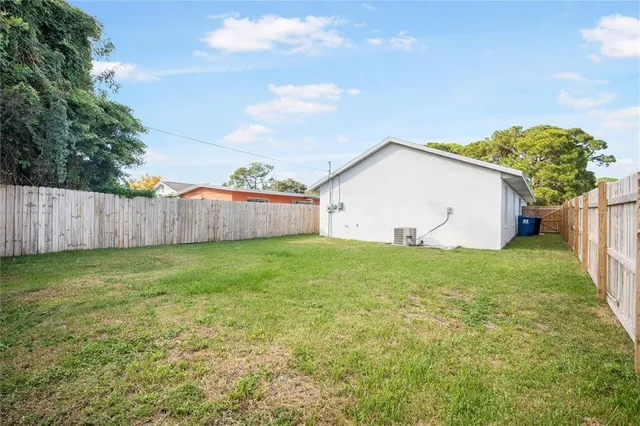 a view of a backyard with grass and a fence
