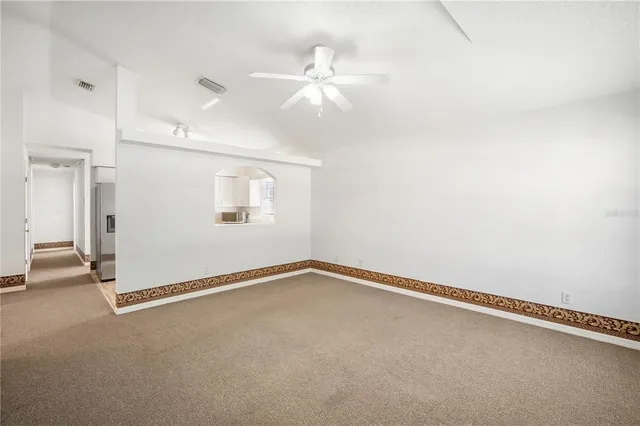 an empty room with a ceiling fan and window