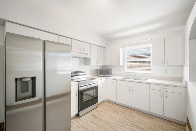 a kitchen with a sink stove and refrigerator