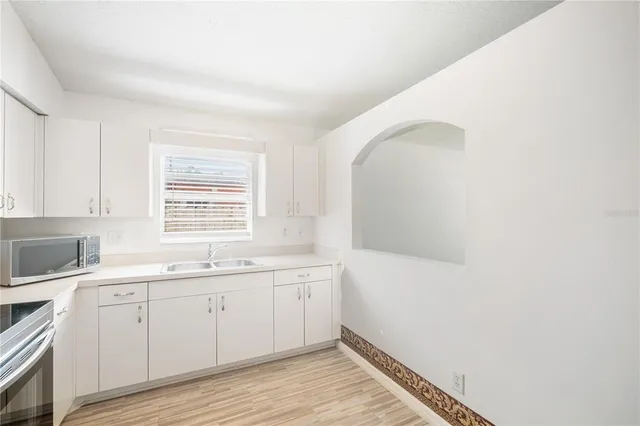a room with a sink cabinets and wooden floor