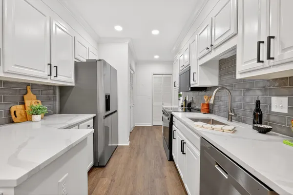 a kitchen with a stove and a white wooden cabinets