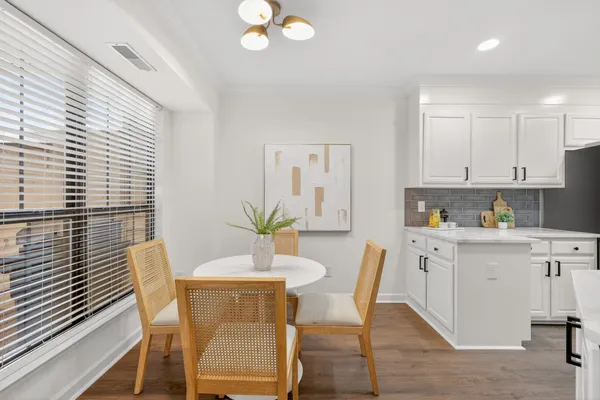 a dining room with wooden floor and a chandelier