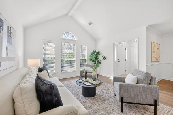 a dining room with wooden floor a chandelier a wooden table and chairs