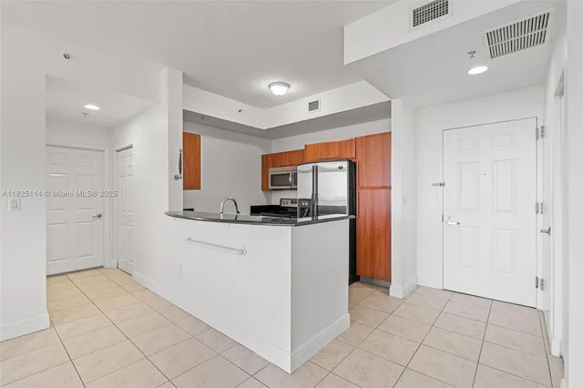 a kitchen with white cabinets and refrigerator