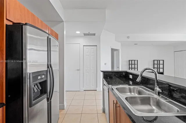a kitchen with stainless steel appliances granite countertop a sink and refrigerator