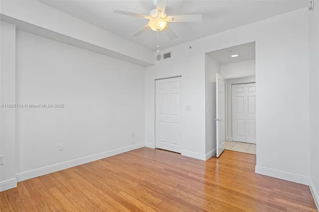 a view of empty room with wooden floor