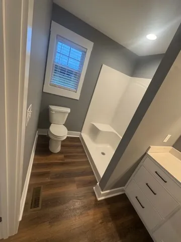 a view of a hallway with wooden floor and a living room