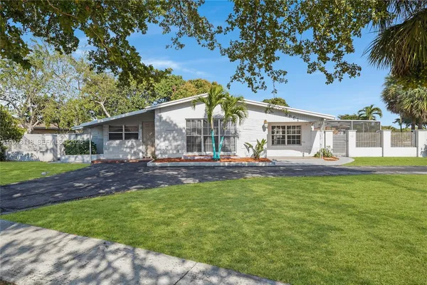 a view of a house with backyard and sitting area