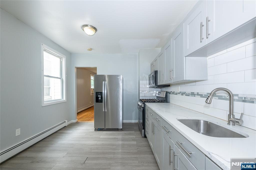 65 Grove Street Bloomfield, NJ 07003 - Photo 35 of 50 a kitchen with stainless steel appliances granite countertop a sink and a refrigerator