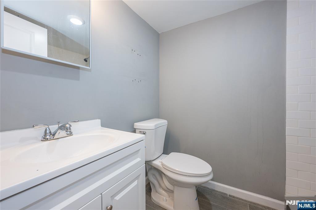 65 Grove Street Bloomfield, NJ 07003 - Photo 43 of 50 a bathroom with a sink a toilet and a mirror